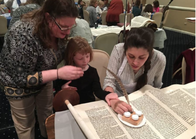 Alex repairing a torah scroll with congregants in Long Island, NY