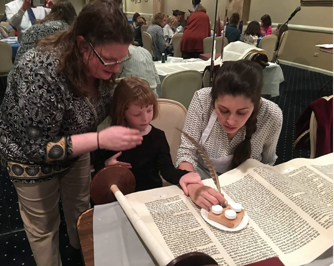 Alex repairing a torah scroll with congregants in Long Island, NY