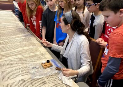 Alex teaches religious school students about caring for torah scrolls in Minnetonka, MN